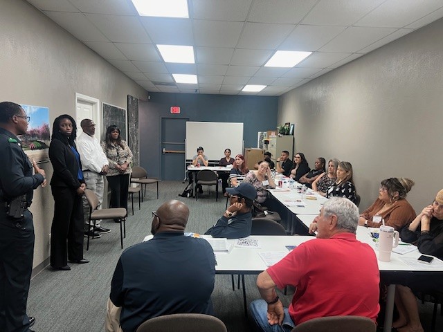 A wide view of speakers and attendees gathered for the small-group manager meeting.